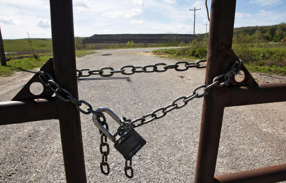 In this April 8, 2019, photo, the entrance to the coal-waste dump site is padlocked in Bokoshe, Okla. President Donald Trump’s EPA has approved Oklahoma to be the first state to take over permitting and enforcement on coal-ash sites. (AP Photo/Sue Ogrocki)