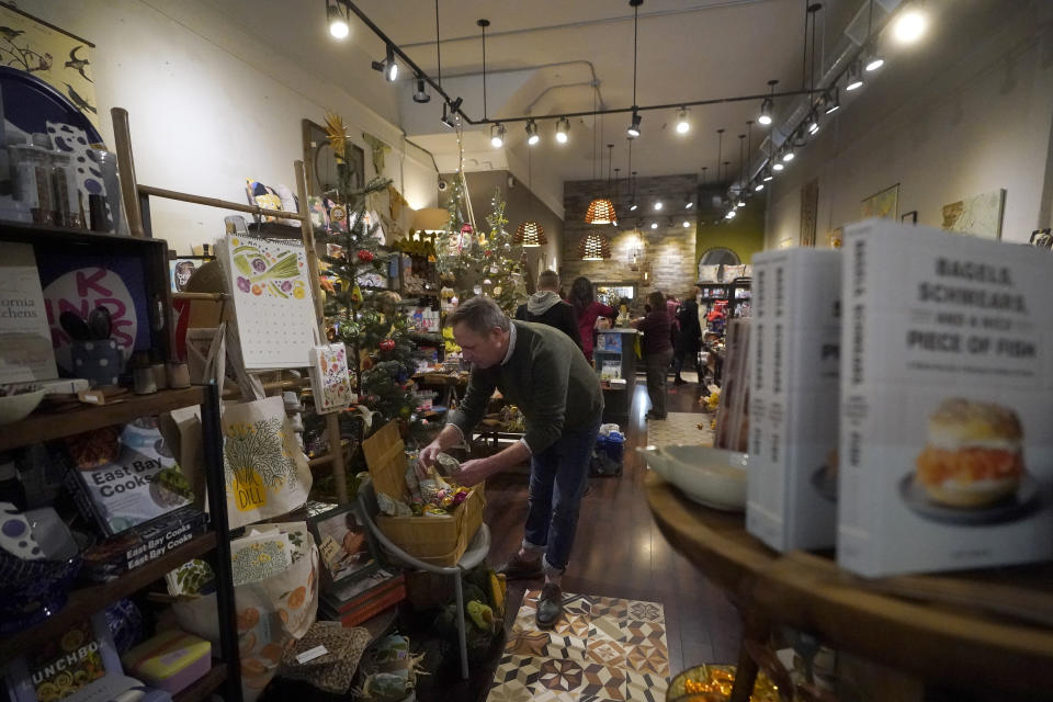 Nathan Waldon, owner of Nathan & Co., organizes items while interviewed at his store in Oakland, Calif., Monday, Dec. 12, 2022. Small retailers say this year looks much different than the last "normal" pre-pandemic holiday shopping season of 2019. They're facing decades-high inflation forcing them to raise prices and making shoppers rein in the freewheeling spending seen in 2021 when they were flush with pandemic aid and eager to spend. (AP Photo/Jeff Chiu)