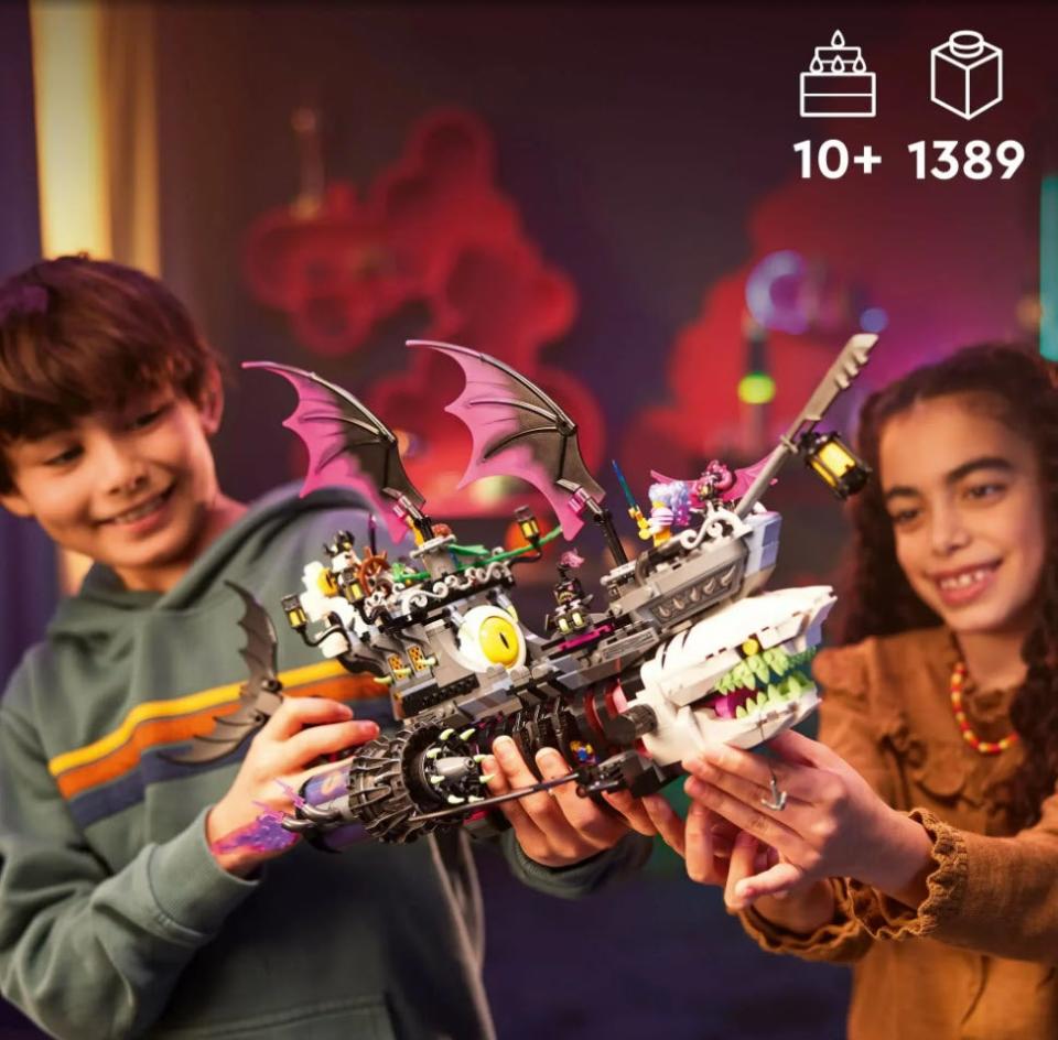 two kids playing with Lego toy shark ship with wings