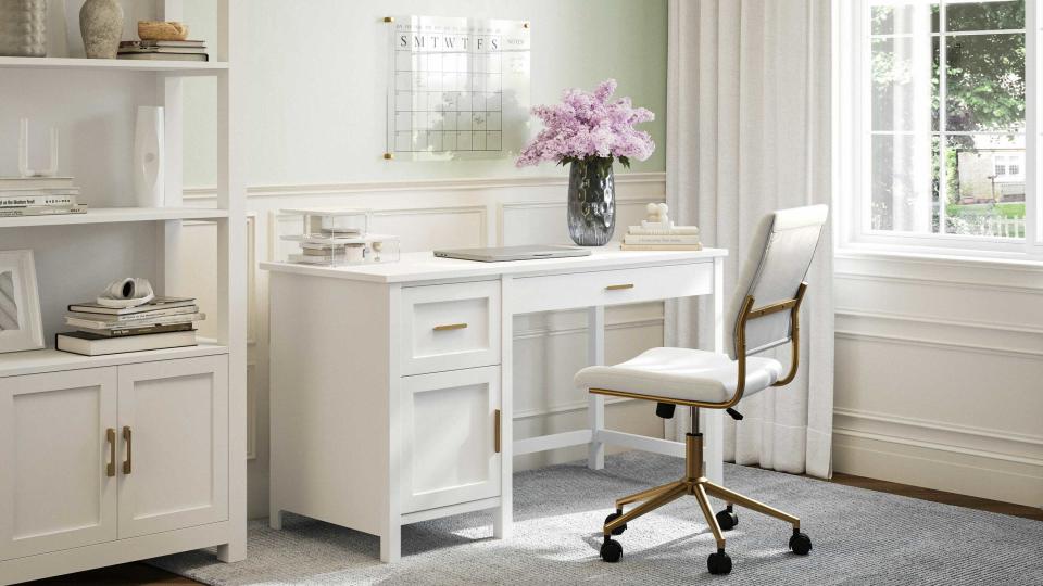 a all white home office set up with purple flowers in a vase