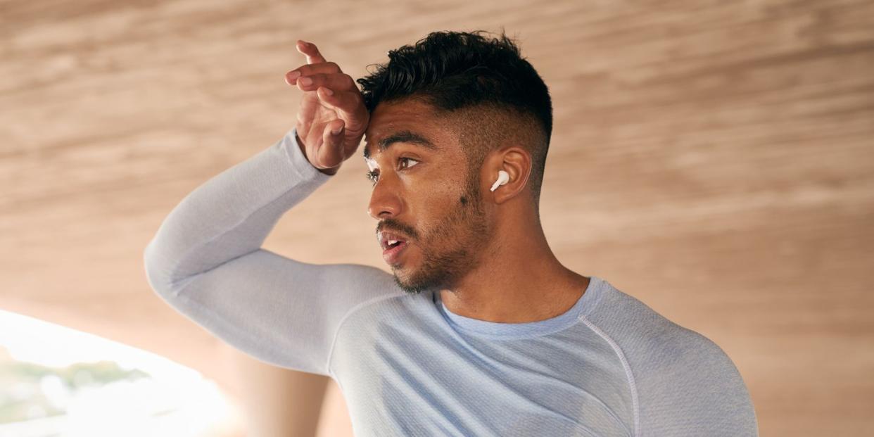 shot of a sporty young man catching his breath while exercising outdoors