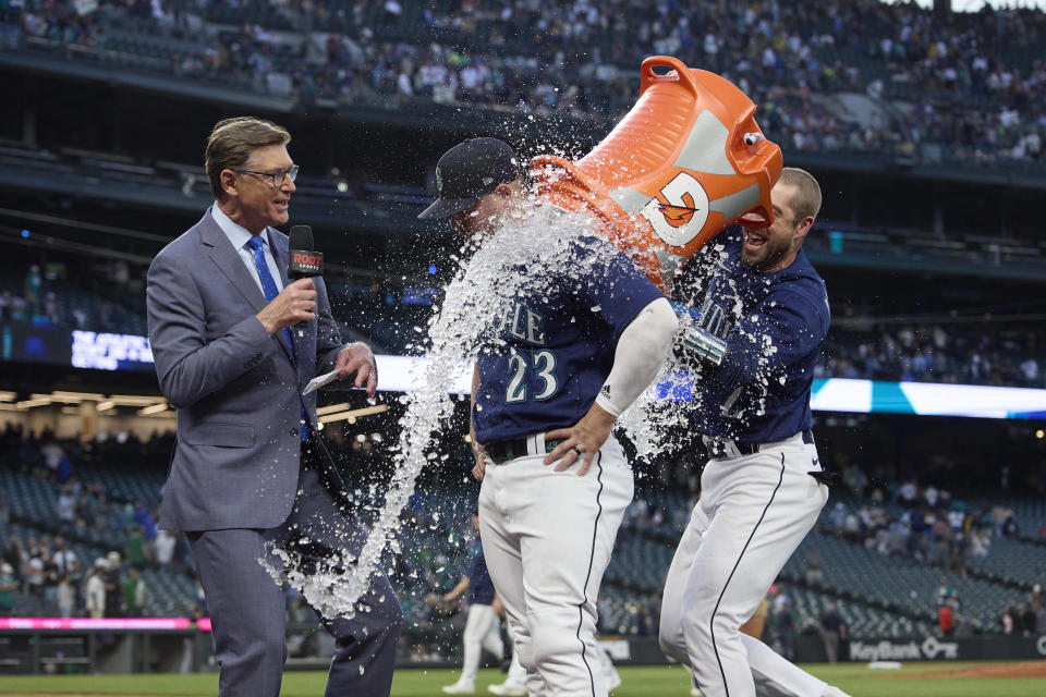Seattle Mariners' Ty France is doused with ice water by Tom Murphy as he is interviewed after the team's 3-2 win over the Oakland Athletics in a baseball game Thursday, May 25, 2023, in Seattle. (AP Photo/John Froschauer)