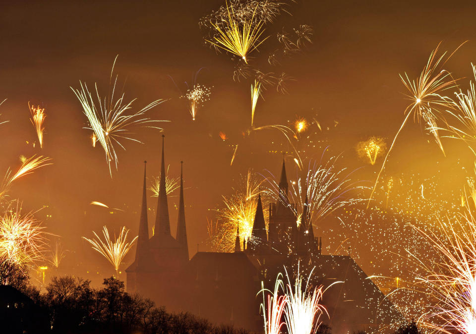 Fireworks light the sky above the Mariendom (Cathedral of Mary), right, and the St. Severi's Church, left, shortly after midnight during New Year's Eve celebrations in Erfurt, central Germany, Wednesday, Jan 1, 2014. (AP Photo/Jens Meyer)