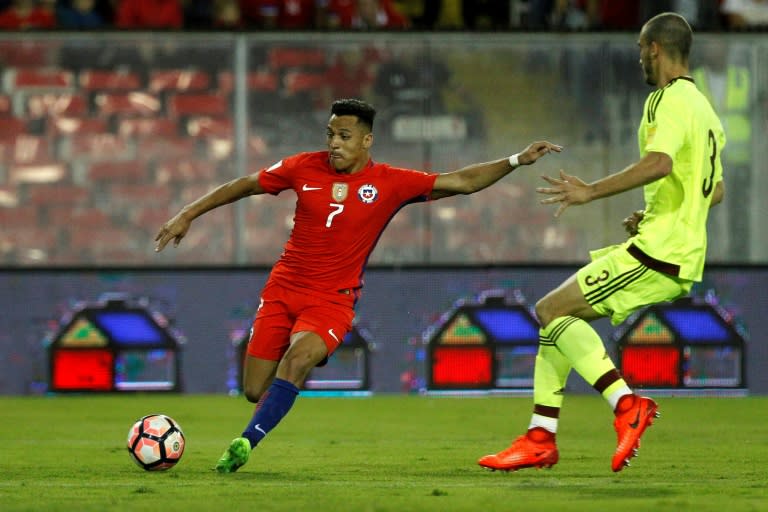 Chile's Alexis Sanchez (L) controls the ball next to Venezuela's Mike Villanueva during their Russia 2018 World Cup qualifier match, in Santiago, on March 28, 2017