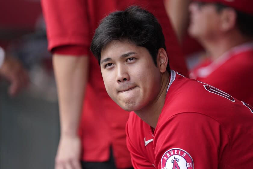 Los Angeles Angels' Shohei Ohtani sits in the dugout during the first inning.