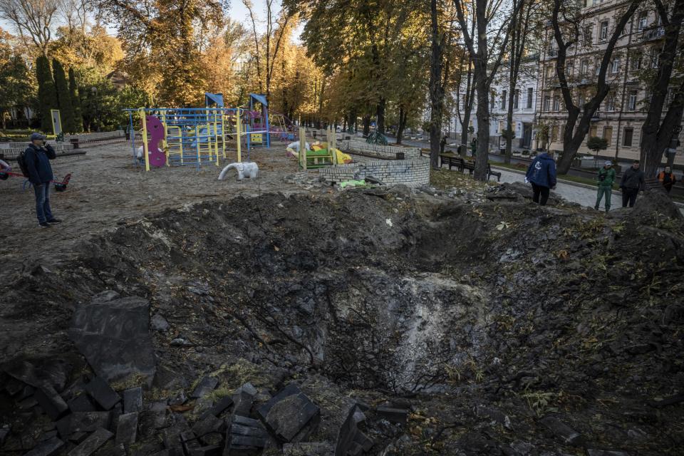 KYIV, UKRAINE - OCTOBER 11: People look at the crater left by a missile strike on a playground in Taras Shevchenko Park the day before on October 11, 2022 in Kyiv, Ukraine. Ukraine's emergency services said that 19 people were killed across the country yesterday in a widespread Russian attack on major cities, including the capital. (Photo by Ed Ram/Getty Images)