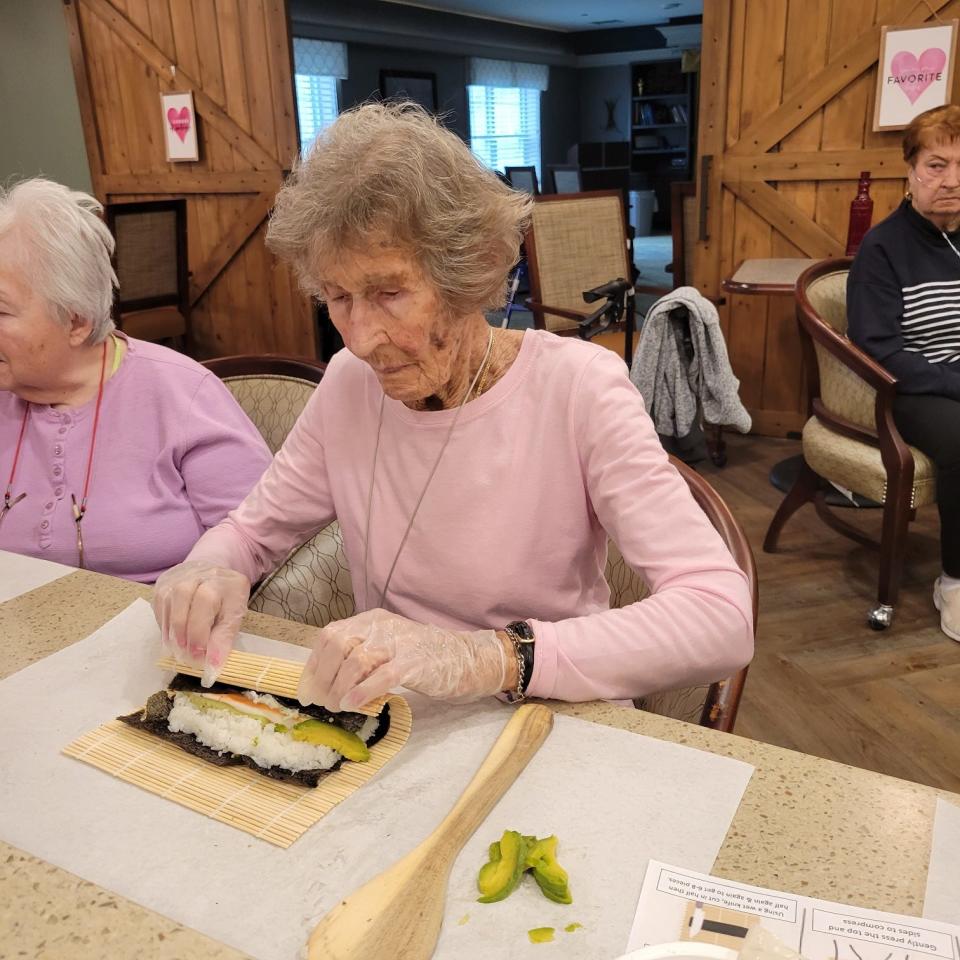 Resident Betty Simpson was very serious about getting that sushi roll technique just right during Culinary Club.