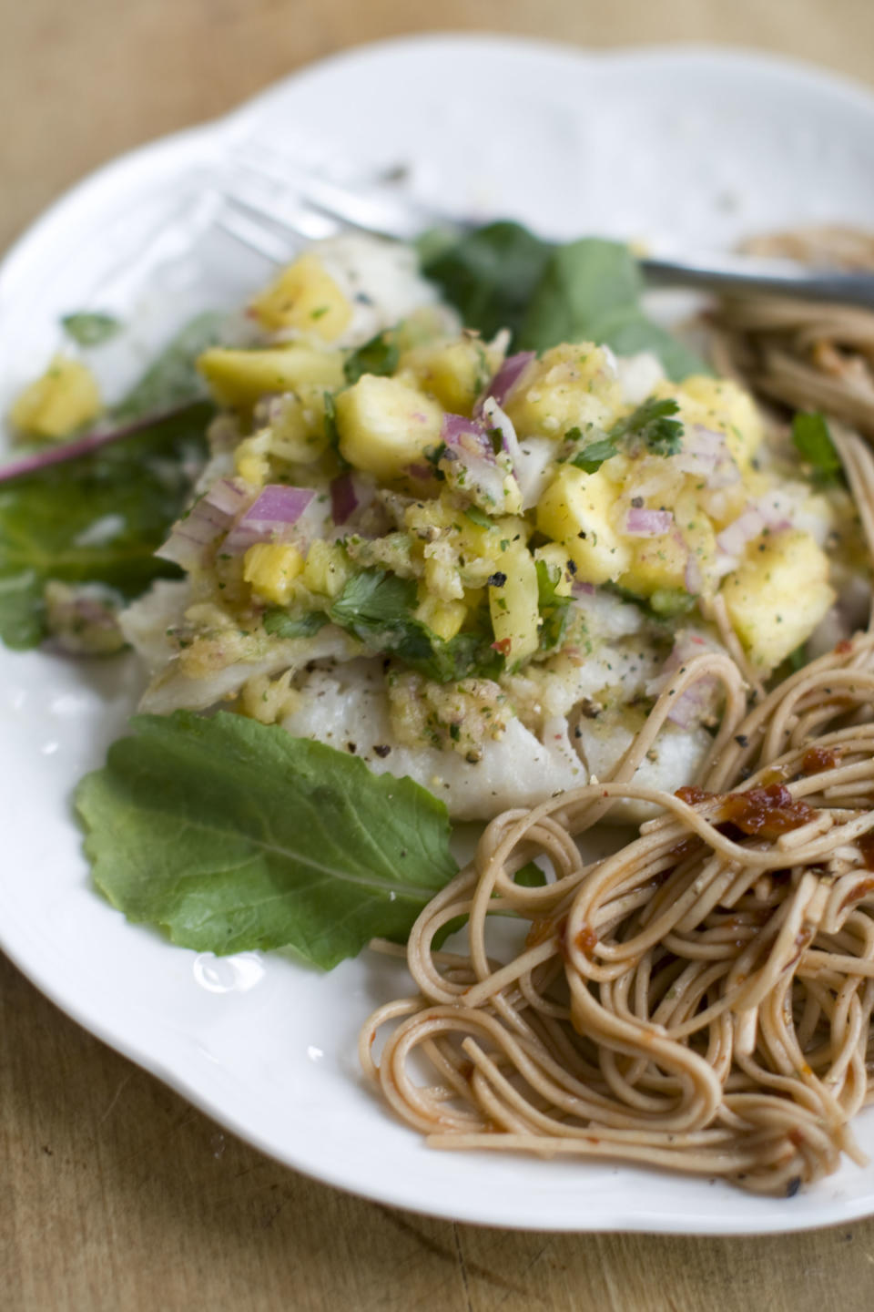 This Dec. 2, 2013 photo shows baked haddock with pineapple mint salsa in Concord, N.H. Baked white fish is a fast and healthy way to get dinner on the table. The secret to getting a good tasting baked white fish, without adding tons of fat and calories or rendering it a tasteless hunk of protein, is all in how you dress it. (AP Photo/Matthew Mead)