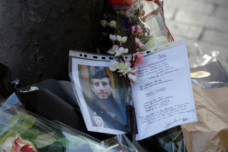 A photo and a letter displayed at the site of a shooting on the Champs Elysees which left one police officer dead and wounded two others