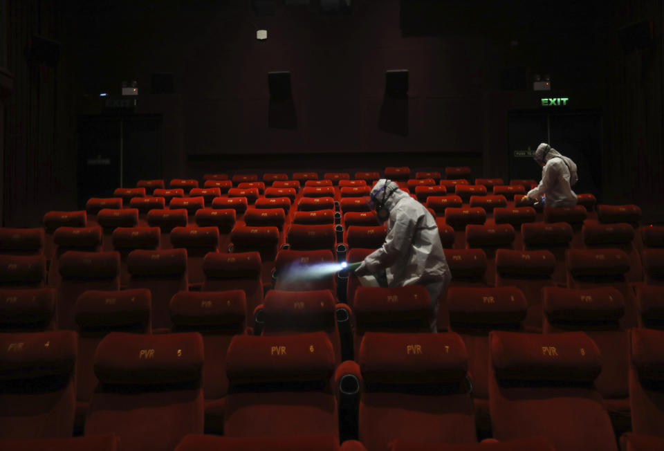 Workers of PVR cinemas, a multiplex cinema chain, sanitizes a hall during a press preview to show their preparedness with the COVID-19 pandemic in New Delhi, India, Friday, July 31, 2020. (AP Photo/Manish Swarup)