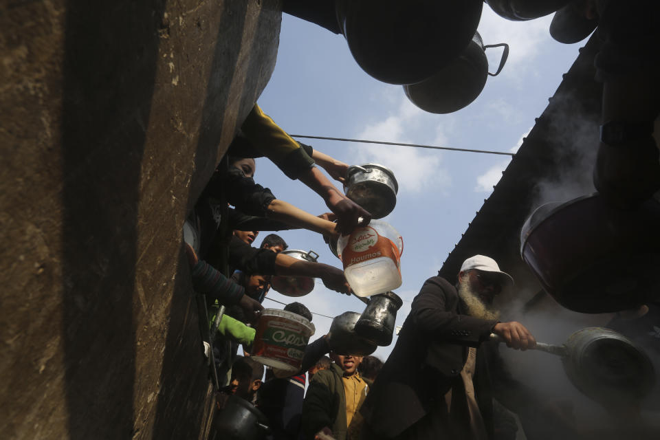 Palestinians line up for free food during the ongoing Israeli air and ground offensive on the Gaza Strip in Rafah, Tuesday, Jan. 9, 2024. (AP Photo/Hatem Ali)