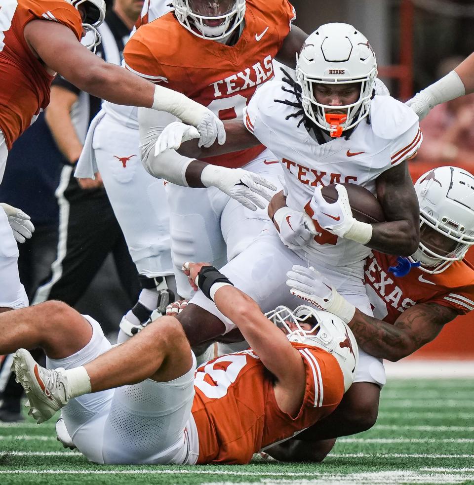 Texas running back CJ Baxter is tackled in Saturday's Orange-White game at Royal-Memorial Stadium. Baxter and Jaydon Blue look like they will carry a heavy load in the backfield, based on the five weeks of spring football.