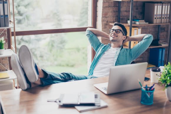 A calm man smiling with his feet up.