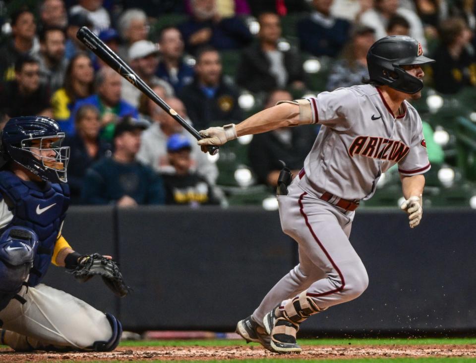 Oct 3, 2022; Milwaukee, Wisconsin, USA; Arizona Diamondbacks left fielder Corbin Carroll (7) hits a triple in the fifth inning as Milwaukee Brewers catcher Victor Caratini (7) watches at American Family Field.