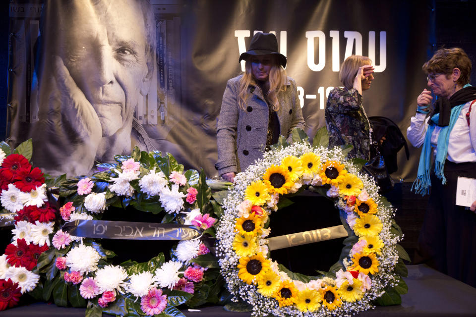 People pay respect by the coffin of Amos Oz during his funeral service in Tel Aviv, Israel, Monday, Dec. 31, 2018. Israeli author Amos Oz, one of the country's most widely acclaimed writers and a pre-eminent voice in its embattled peace movement, died on Friday after a battle with cancer, his family announced. He was 79. (AP Photo/Ariel Schalit)