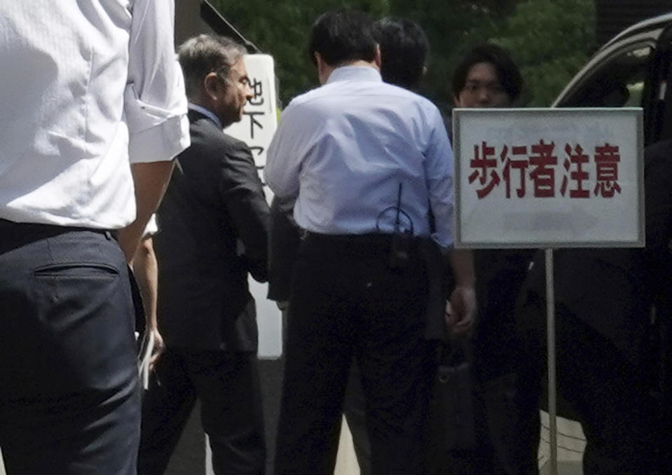 Former Nissan chairman Carlos Ghosn, second from left, arrives at Tokyo District Court for a pre-trial meeting Thursday, May 23, 2019, in Tokyo. Ghosn, who is out on bail, has been charged with under-reporting his post-retirement compensation and breach of trust in diverting Nissan money and allegedly having it shoulder his personal investment losses. (AP Photo/Eugene Hoshiko)