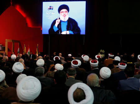 FILE PHOTO:Lebanon's Hezbollah leader Sayyed Hassan Nasrallah is seen on a video screen as he addresses his supporters in Beirut, Lebanon February 16, 2018. REUTERS/Aziz Taher/File Photo