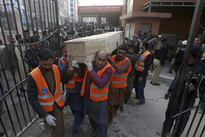 Volunteers carry a coffin of a man, killed in the suicide bombing inside a mosque, at a hospital, in Peshawar, Pakistan, Monday, Jan. 30, 2023. A suicide bomber struck Monday inside a mosque in the northwestern Pakistani city of Peshawar, killing multiple people and wounding scores of worshippers, officials said. (AP Photo/Muhammad Sajjad)