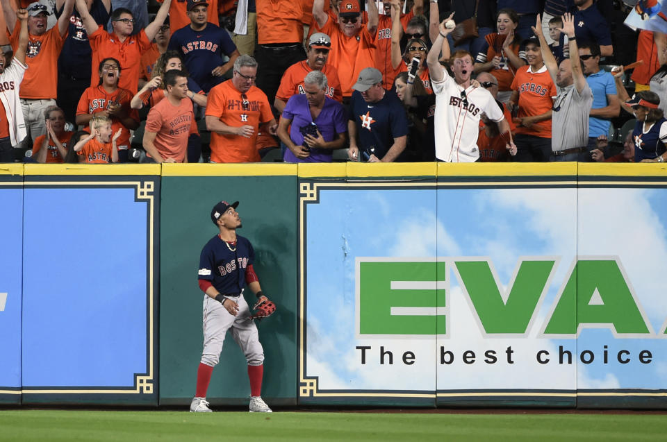 Boston Red Sox right fielder Mookie Betts watches as a fan holds a home run ball hit by Houston Astros’ George Springer during the third inning in Game 2 of baseball’s American League Division Series, on the bright side, Betts didn’t have to try throwing this one back in. (AP Photo)