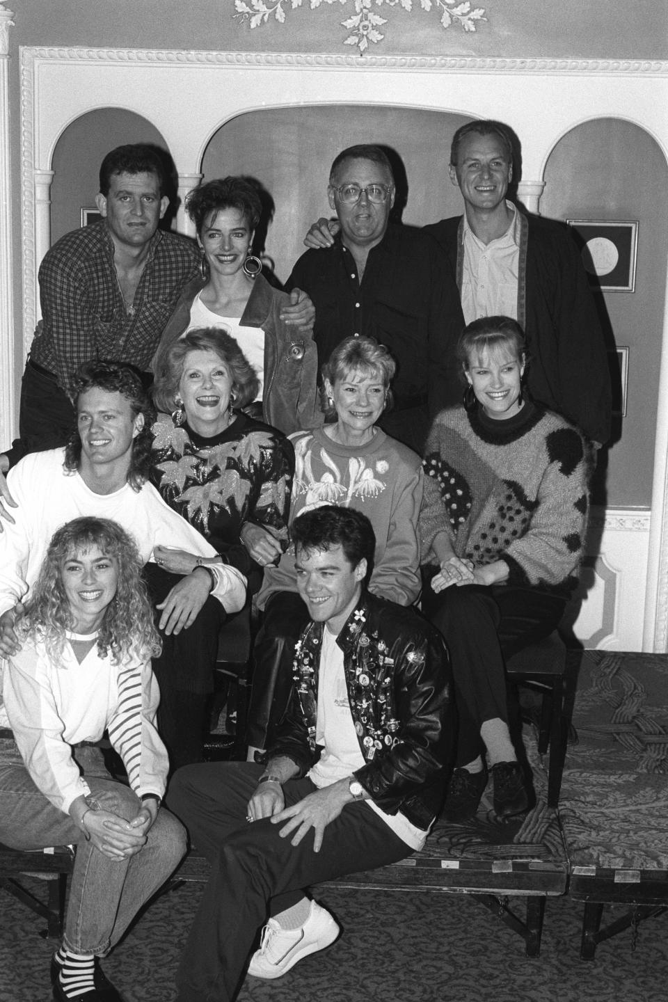 The cast of the Australian soap opera 'Neighbours' settling in at the Dorchester Hotel in London after they jetted in to appear in the Royal Variety Show. (Front, l-r) Annie Jones (Jane) and Stefan Dennis (Paul). (Middle, l-r) Craig McLachlan (Henry), Anne Charleston (Madge), Anne Haddy (Helen) and Elaine Smith (Daphne). (Back, l-r) Paul Keane (Des), Fiona Corke (Gail), Ian Smith (Harold) and Alan Dale (Jim).