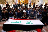 Mourners pray near a coffin of a demonstrator who was killed at an anti-government protest overnight in Nassiriya, during a funeral in Najaf