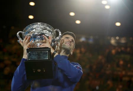 Serbia's Novak Djokovic celebrates with the men's singles trophy after winning his final match against Britain's Andy Murray at the Australian Open tennis tournament at Melbourne Park, Australia, January 31, 2016. REUTERS/Issei Kato