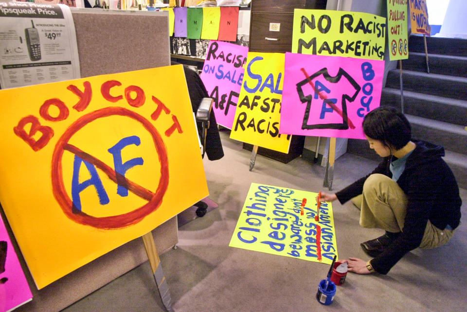 Pauli Wai of the Chinatown Community Developement Center works on posters before a demonstration in San Francisco on April 18, 2002, to protest about a line of five T-shirts depicting stereotypes that were sold by Abercrombie & Fitch. (Paul Sakuma / AP file)