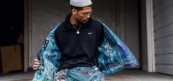 An artist poses in a Nike sweatshirt.