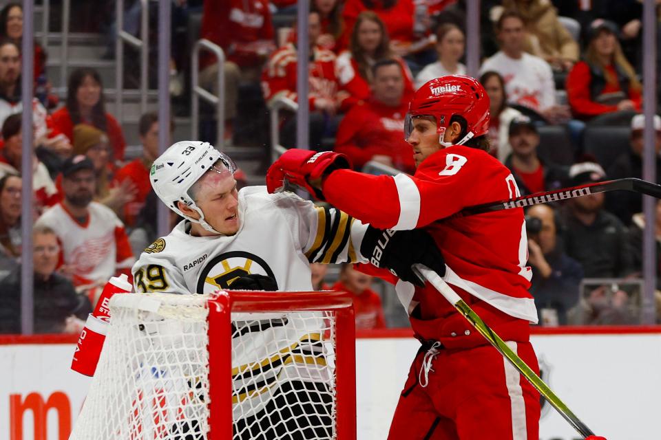 Detroit Red Wings defenseman Ben Chiarot (8) scuffles with Boston Bruins center Morgan Geekie (39) during the first period of the game between the Boston Bruins and the Detroit Red Wings at Little Caesars Arena in Detroit on Sunday, Dec. 31, 2023.