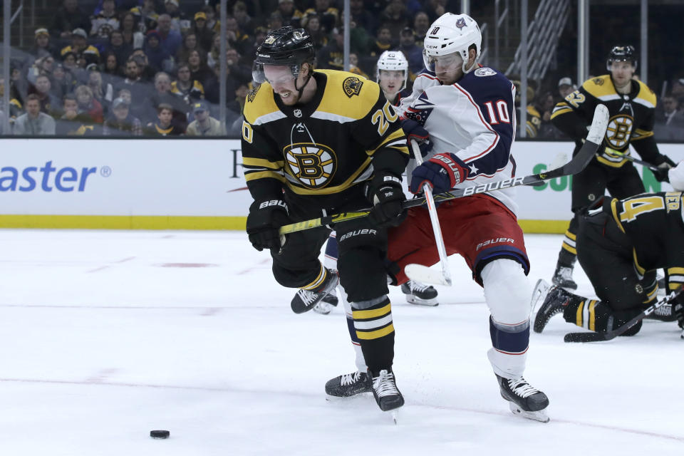 Boston Bruins center Joakim Nordstrom (20) and Columbus Blue Jackets center Alexander Wennberg (10) compete for the puck in the second period of an NHL hockey game, Thursday, Jan. 2, 2020, in Boston. (AP Photo/Elise Amendola)