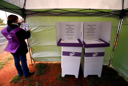 Official Heather McInerney hangs a 'No Litter' sign next to voting stands as she prepares a remote voting station in the western New South Wales outback town of Enngonia, Australia, June 22, 2016. REUTERS/David Gray