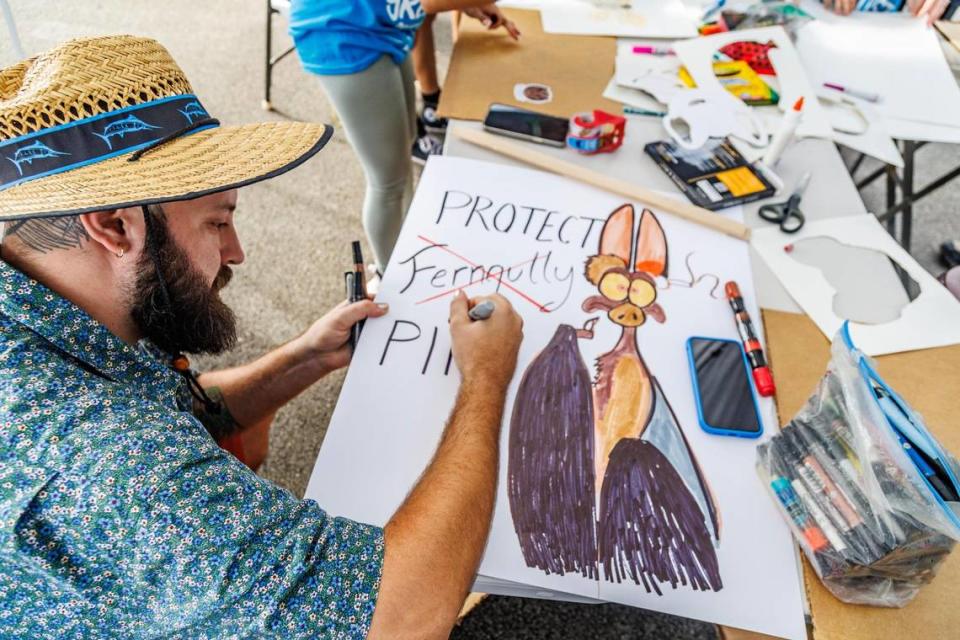 Artist Alexander Zastera finishes a poster he’ll display at a rally led by Ron Magill, the communications director at Zoo Miami to convince the Miami-Dade commission to vote against the controversial plan to build the Miami Wilds water park, next to Zoo Miami, on Saturday, November 4, 2023.