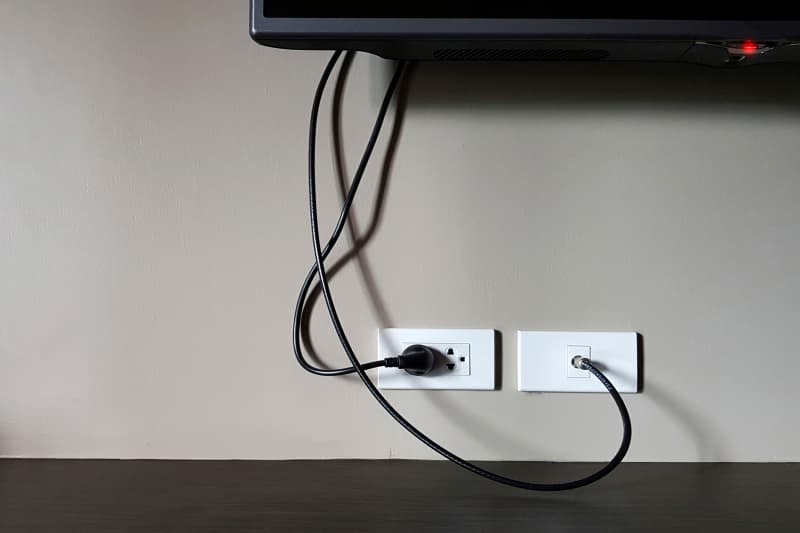 An electrical socket and TV outlet in the drywall in the room of in apartment,Electrical plug and TV signal outlets on white wall.