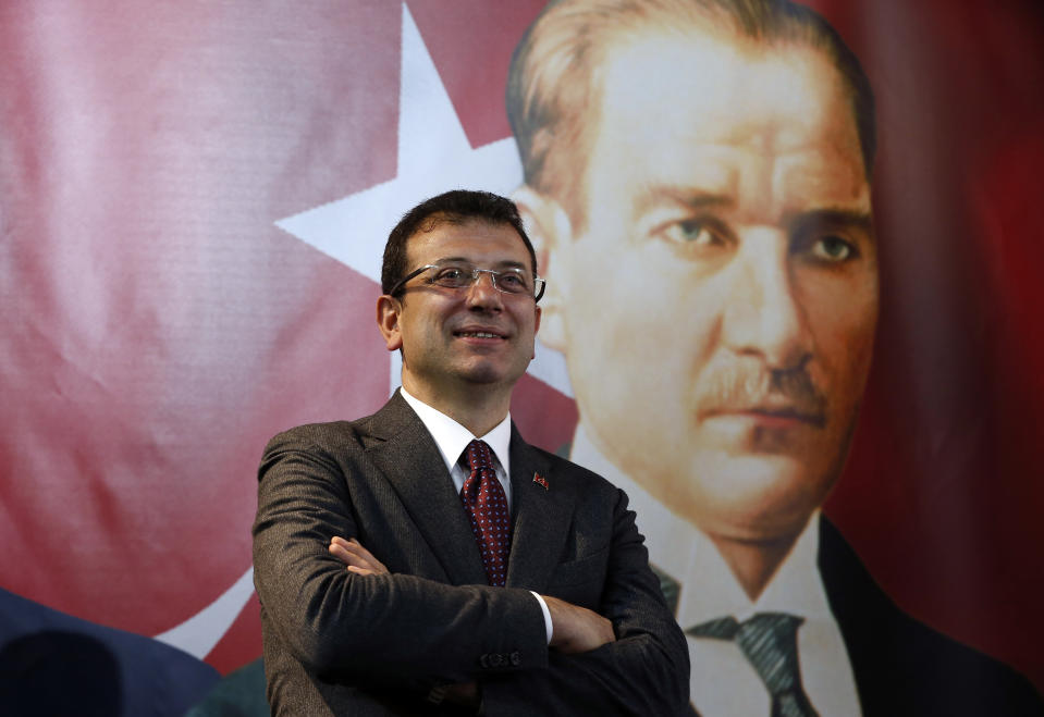 Backdropped by a poster of modern Turkey's founder Mustafa Kemal Ataturk, right, Ekrem Imamoglu, the opposition, Republican People's Party's (CHP) mayoral candidate in Istanbul, poses for The Associated Press following an interview in Istanbul, Thursday, April 4, 2019. Imamoglu said he's confident that the result of a recount of votes in the city will confirm his victory and has renewed an appeal to Turkey's President Recep Tayyip Erdogan to help end the standoff. Imamoglu won the tight race for Istanbul in Sunday's local elections in a major upset for Erdogan, who rose to power as the mayor of the city of 15 million and has said that whoever wins Istanbul wins to whole of Turkey. (AP Photo/Lefteris Pitarakis)