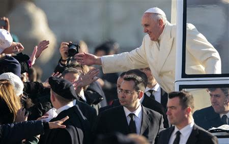 Pope Francis gives blessings as he arrives to lead his Wednesday general audience in Saint Peter's square at the Vatican December 18, 2013. REUTERS/Tony Gentile