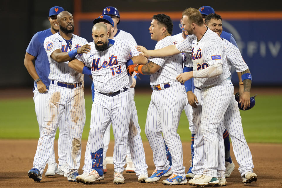 Teammates celebrate with New York Mets' Luis Guillorme (13) after he hit a walkoff RBI single during the 10th inning of the baseball game against the Los Angeles Dodgers at Citi Field, Sunday, July 16, 2023, in New York. (AP Photo/Seth Wenig)