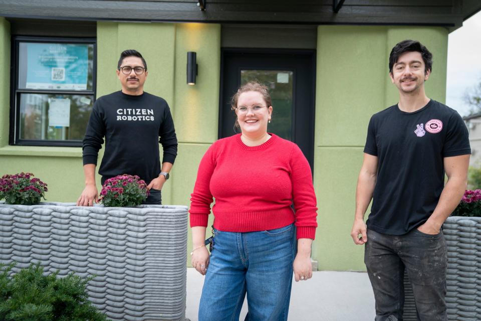 Fernando Bales, 35, of Pontiac, build lab manager of Citizen Robotics, left, Evelyn Woodman, 25, of Grosse Pointe Park, Citizen Robotics co-founder and communications director, and Lucas Aquirre, 30, of Detroit, assistant manager of Citizen Robotics, pose in front of Michigan's first 3D-printed house in Detroit on Monday, Sept. 25, 2023.