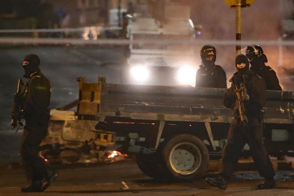 Heavily armed police guard a crime scene (PA)