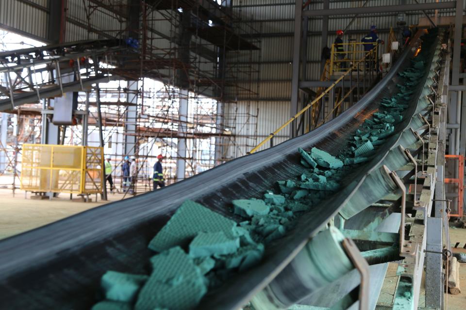 A conveyor belt carries chunks of raw cobalt.