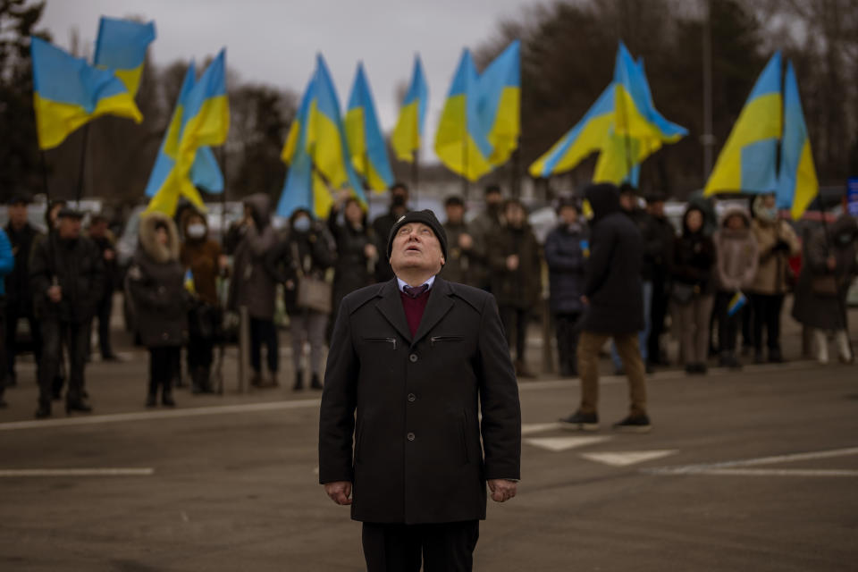 People hold Ukrainian flags as they gather to celebrate a Day of Unity in Odessa, Ukraine, Wednesday, Feb. 16, 2022. As Western officials warned a Russian invasion could happen as early as today, the Ukrainian President Zelenskyy called for a Day of Unity, with Ukrainians encouraged to raise Ukrainian flags across the country. (AP Photo/Emilio Morenatti)