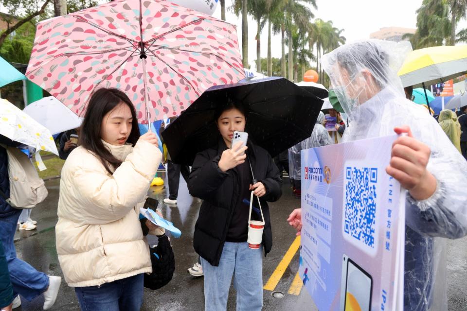 儘管天氣不佳，學生們仍撐傘冒著低溫參加徵才博覽會。廖瑞祥攝