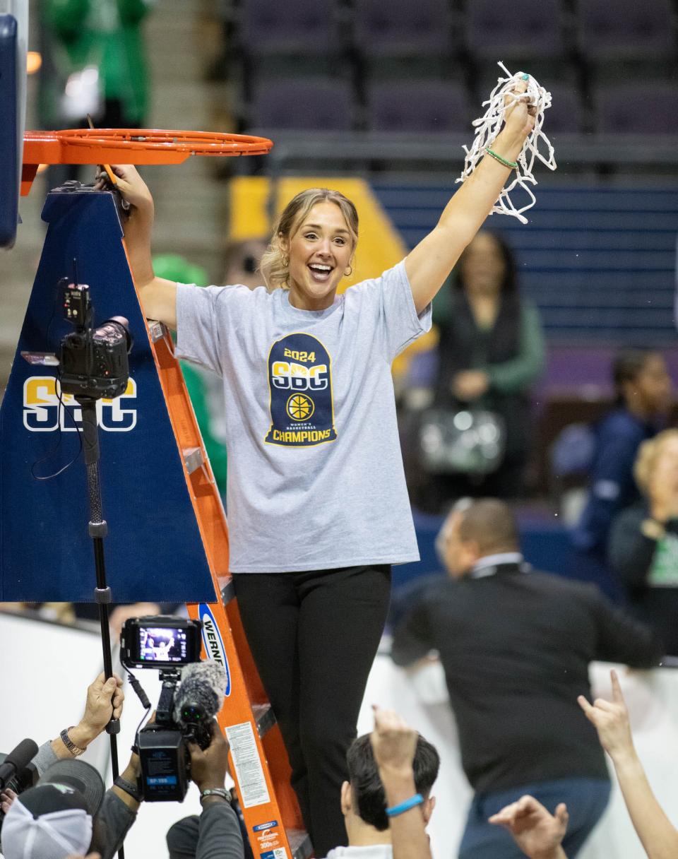 The Thundering Herd head coach Kim Caldwell cuts down the net as they celebrate their victory in the James Madison vs Marshall basketball game in the finals of the Sun Belt Conference women's Basketball Championship at the Pensacola Bay Center in Pensacola, Florida, on Monday, March 11, 2024. The Thundering Herd defeat the Dukes 95-92 in overtime.