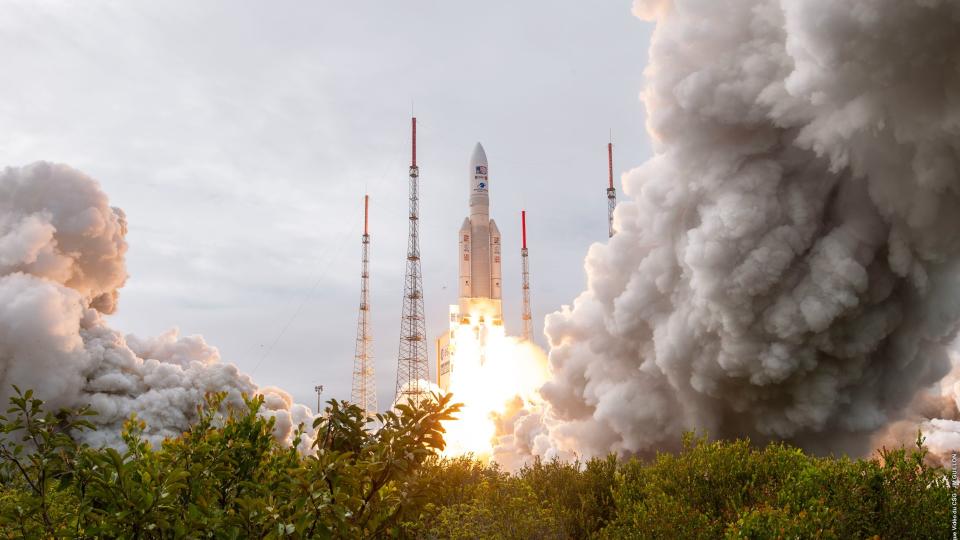 a rocket launches above trees