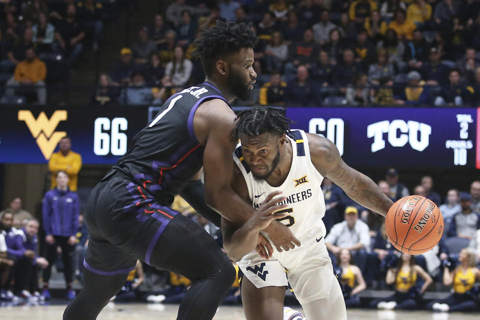 West Virginia guard Joe Toussaint (5) is defended by TCU guard Mike Miles Jr. (1) during the second half of an NCAA college basketball game Wednesday, Jan. 18, 2023, in Morgantown, W.Va. (AP Photo/Kathleen Batten)