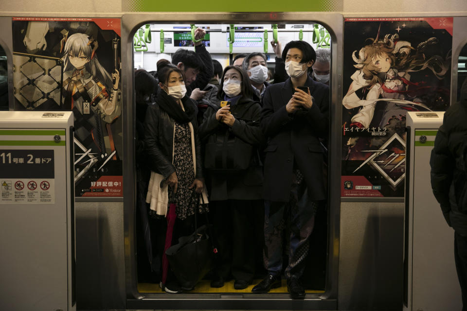 FILE - In this March 2, 2020, file photo, commuters wearing masks stand in a packed train at the Shinagawa Station in Tokyo. During commuting hours, almost everyone on public transportation wears a mask. (AP Photo/Jae C. Hong, File)
