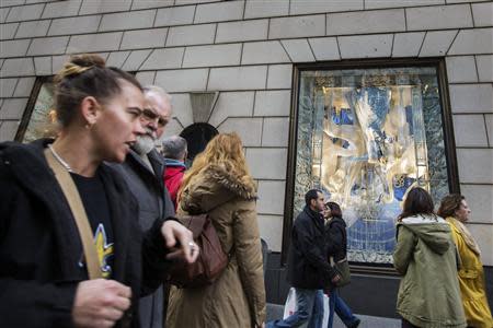 Pedestrians walk past holiday windows at the Bergdorf Goodman store in New York, November 22, 2013. REUTERS/Lucas Jackson