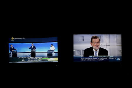 Two screens are seen in this photo illustration showing three of the main candidates for Spain's national election at a live debate hosted by Spanish newspaper El Pais (L) and Spanish Prime Minister Mariano Rajoy (R), who declined to attend that debate, at a simultaneous live interview at Telecinco TV in Madrid, Spain, November 30, 2015. The three main candidates are (L-R) Ciudadanos party leader Albert Rivera, Socialist party (PSOE) leader Pedro Sanchez and Podemos (We Can) party leader Pablo Iglesias. REUTERS/Susana Vera