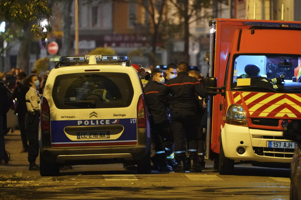 Police officers and rescue workers block the access to the scene after a Greek Orthodox priest was shot Saturday Oct.31, 2020 while he was closing his church in the city of Lyon, central France. The priest, a Greek citizen, is in a local hospital with life-threatening injuries after being hit in the abdomen, a police official told The Associated Press. (AP Photo/Laurent Cipriani)