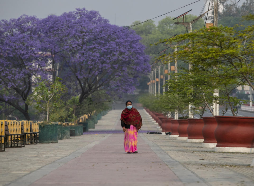 A Nepalese woman walks on a deserted street during the first day of lockdown in Kathmandu, Nepal, Thursday, April 29, 2021. Offices were closed, markets were shuttered and vehicles were forced off the street in Nepal's capital on Thursday as authorities imposed a 15-day lockdown because of spiking cases of COVID-19 in the country. (AP Photo/Niranjan Shrestha)