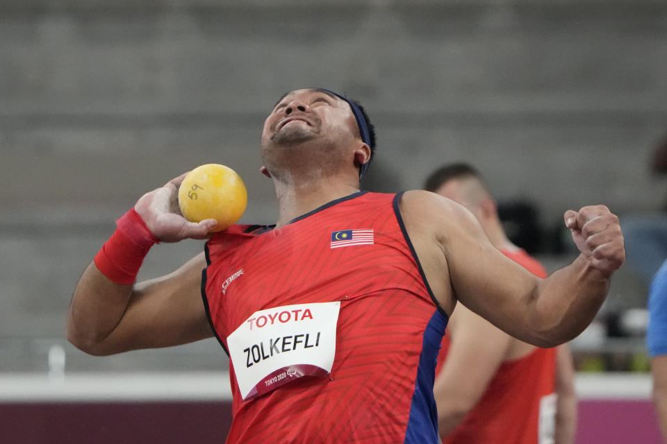 FILE - In this Tuesday, Aug. 31, 2021, file photo, Muhammad Ziyad Zolkefli of Malaysia competes in the men's shot put F20 final during the Tokyo 2020 Paralympics Games at the National Stadium in Tokyo. Zolkefli appeared to have won gold in the shot put in the F20 class. But after the victory on Tuesday, he was disqualified because he had shown up late for the competition. (AP Photo/Eugene Hoshiko, File)